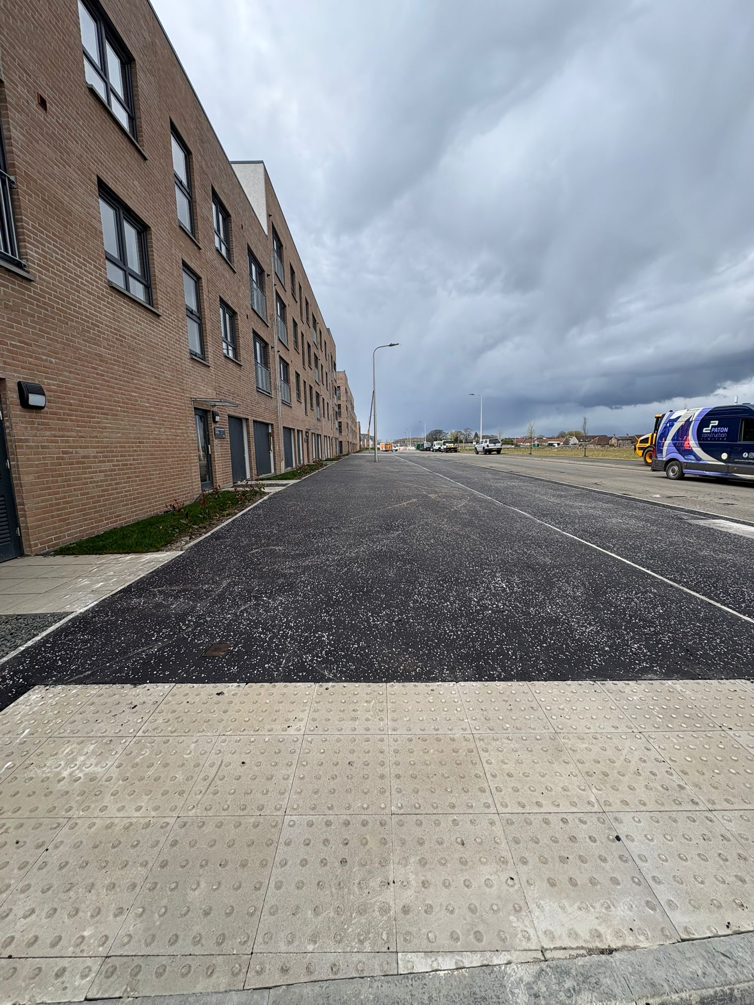 Wide-angle view of completed footpaths and carriageway within the housing development