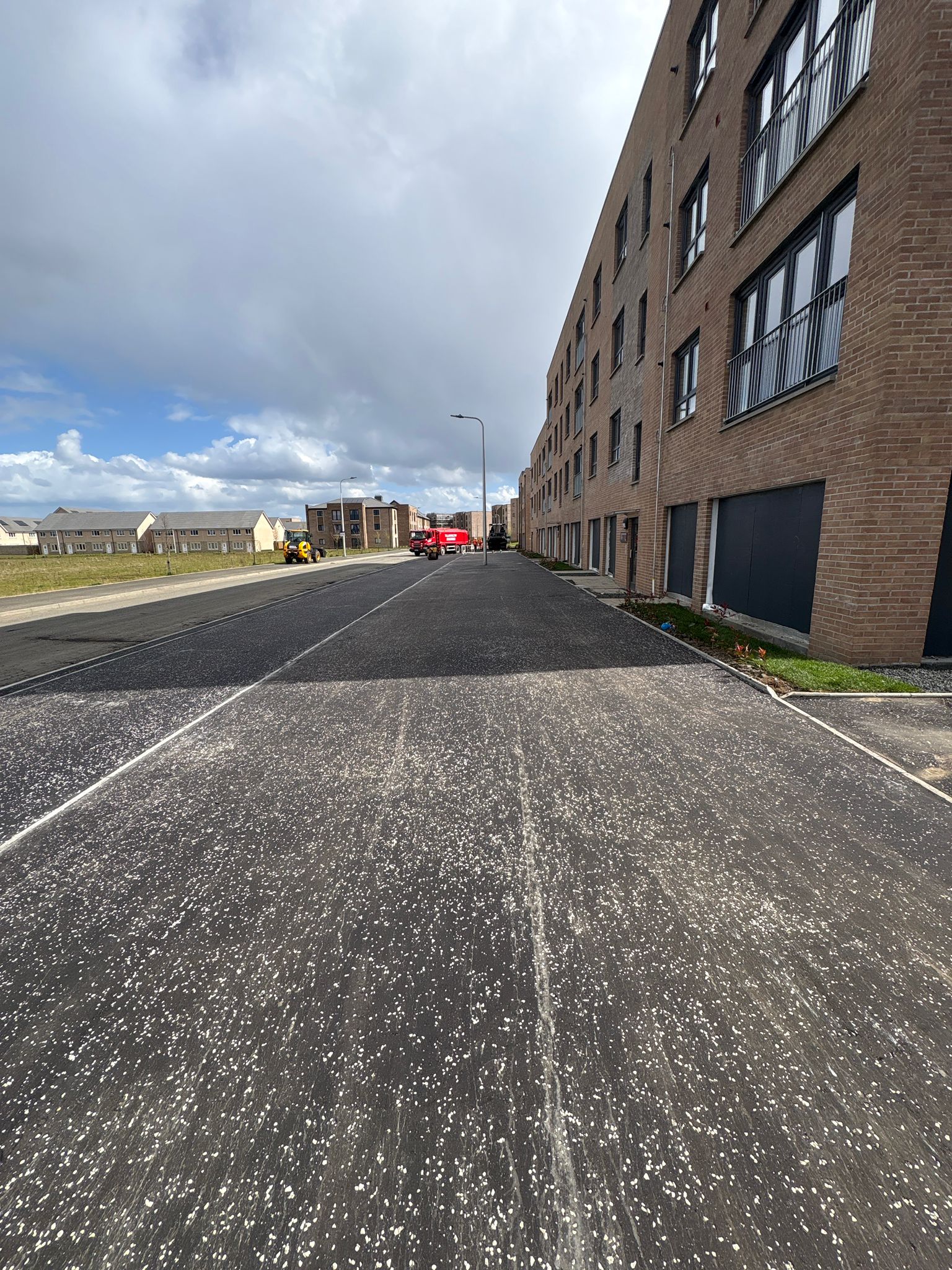 Newly surfaced carriageway alongside residential properties showing consistent finish and alignment