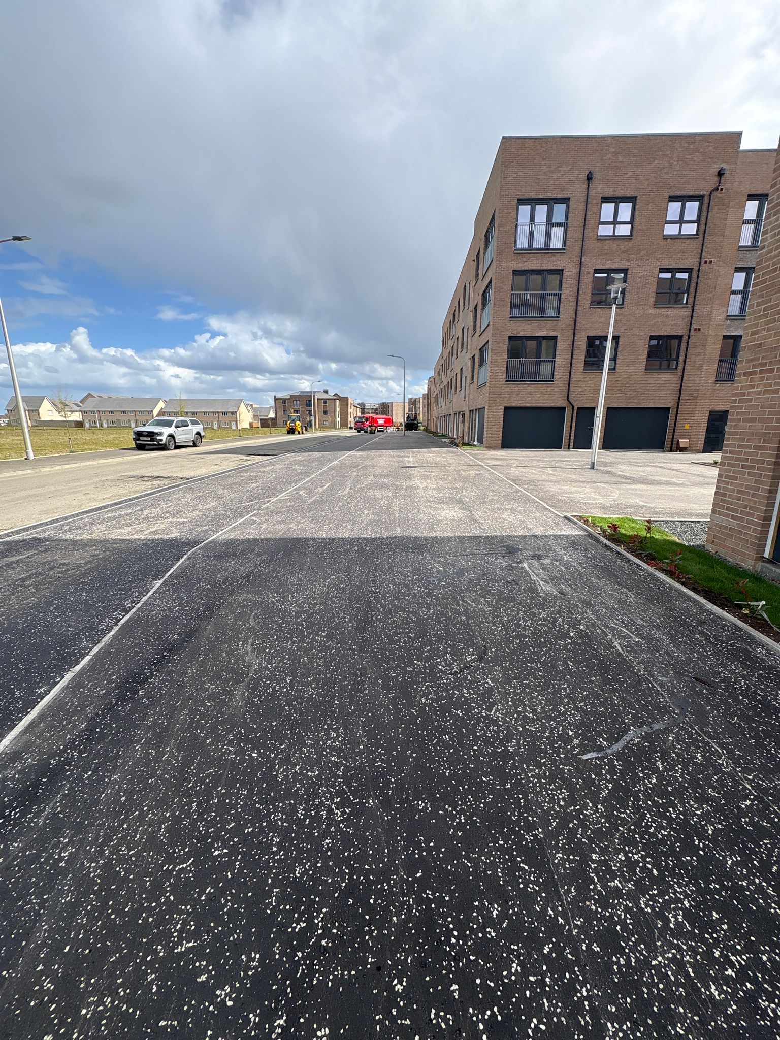 Finished carriageway adjacent to housing blocks demonstrating uniform surface quality and detailing