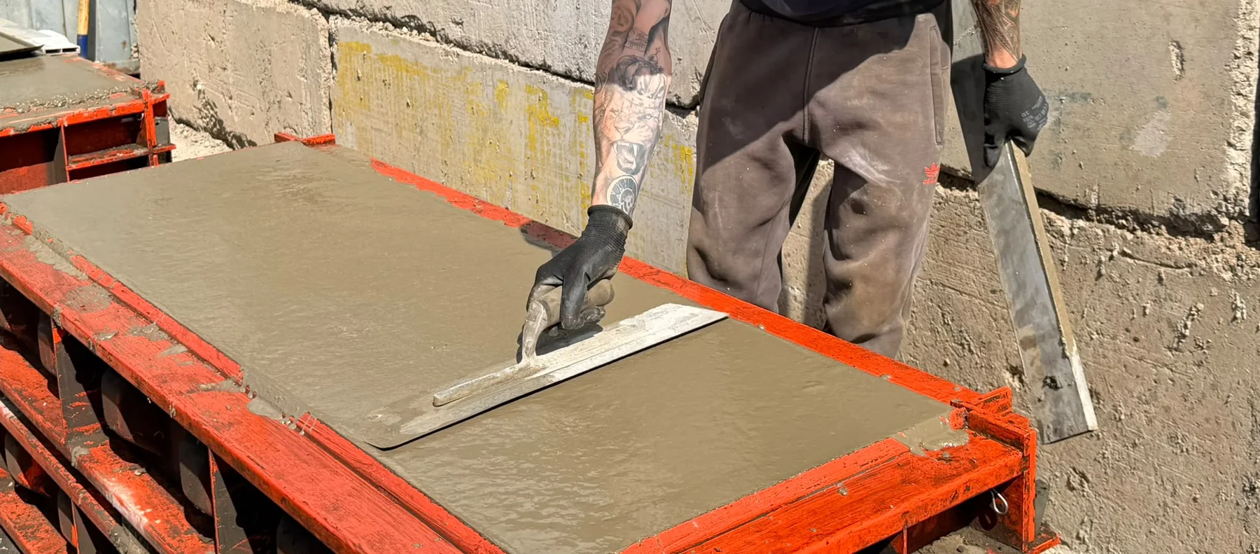 Hand-finishing the surface of a freshly poured concrete block